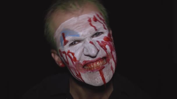 クラウンハロウィン男の肖像画。気味の悪い邪悪なピエロの血の顔白い顔のメイク — ストック動画