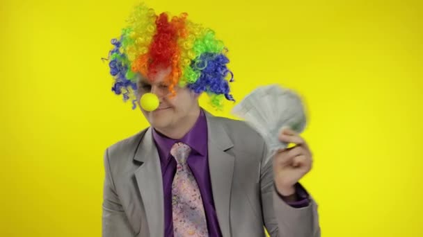 Clown businessman entrepreneur boss in wig with money banknotes at work — Stock Video