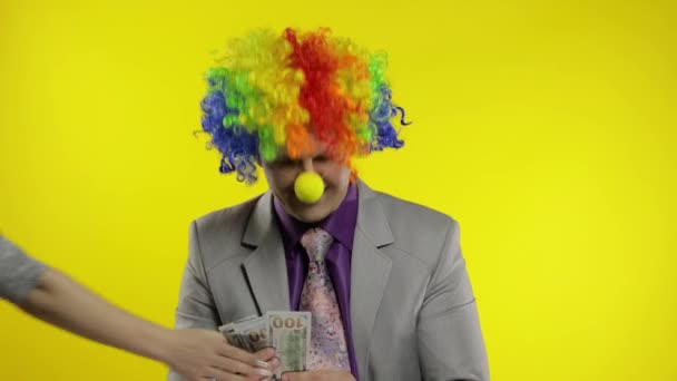 Клоун бізнесмен-підприємець підраховує грошовий дохід. Рука краде готівку у чоловіка — стокове відео
