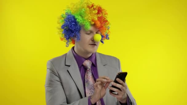 Клоун предприниматель босс предприниматель получает денежный доход при использовании смартфона — стоковое видео