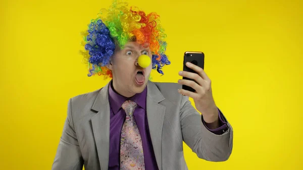 Clown businessman entrepreneur boss in wig making selfies using smartphone — Stock Photo, Image