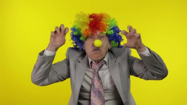 Senior Clown Geschäftsmann Unternehmer Chef macht dumme Gesichter. Gelber Hintergrund — Stockvideo