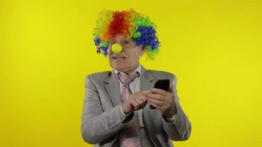 Palyaço işadamı serbest çalışan patron akıllı telefon kullanarak para kazanıyor.
