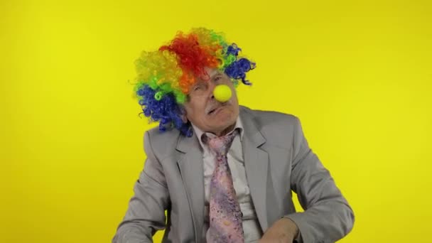 Senior clown businessman entrepreneur boss making silly faces. Yellow background — Stock Video