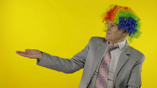 Homme d'affaires clown âgé patron entrepreneur pointant vers quelque chose. Espace de copie — Photo