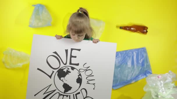 Девушка-активистка держит плакат Love Your Mother Earth. Пластиковые загрязнения природы — стоковое видео