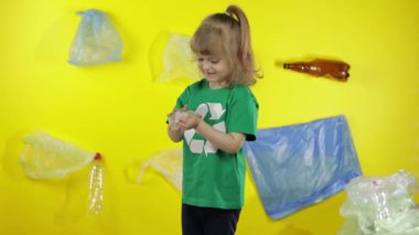 Yeşil tişörtlü, geri dönüşüm logosu olan gönüllü bir kız. Plastik kirliliği