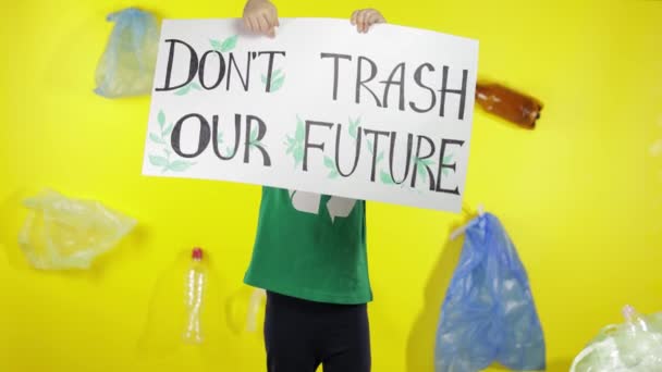 Девушка-активистка держит плакат "Dont Trash Our Future". Снижение загрязнения природы. Окружающая среда — стоковое видео