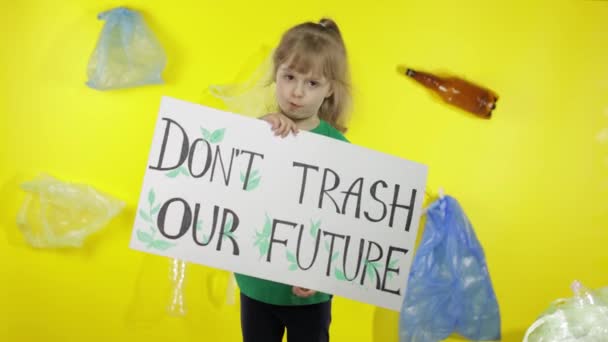 女の子活動家がポスターを持っている私たちの未来をゴミ箱.プラスチック地球の自然汚染を減らす — ストック動画