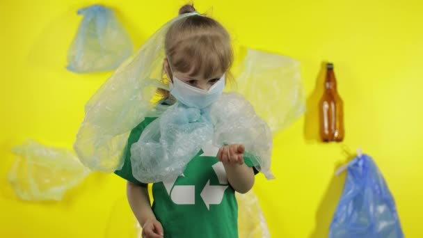 Menina voluntária em embalagens de plástico no pescoço e na cabeça. Reduzir a poluição do plástico. Salvar ecologia — Vídeo de Stock
