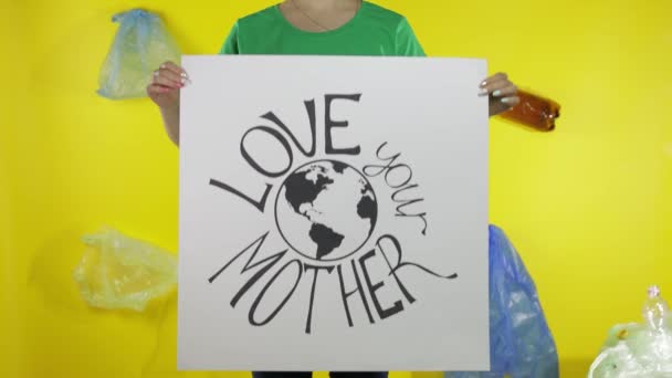 Mulher irreconhecível segurando cartaz de protesto Ame sua Mãe Terra. Ambiente poluição plástica — Vídeo de Stock