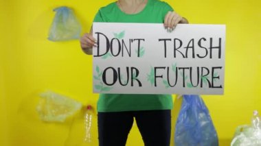Elinde protesto posteri tutan tanınmamış bir kadın Geleceğimizi Mahvetme. Çevre plastik kirliliği