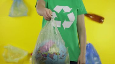 Plastik paketinde Dünya küresi olan tanınmayan bir kadın. Ekolojiyi kurtar. Plastik doğa kirliliği