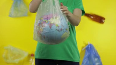 Plastik paketinde Dünya küresi olan tanınmayan bir kadın. Ekolojiyi kurtar. Plastik doğa kirliliği