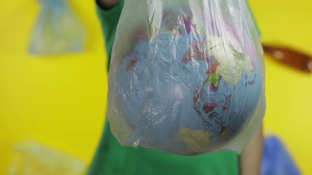 Femme méconnaissable avec globe terrestre dans un emballage en plastique. Sauver l'écologie. Pollution plastique naturelle — Video