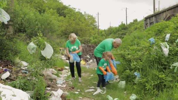 Zespół wolontariuszy sprząta brudny park z plastikowych toreb, butelek. Zmniejszenie zanieczyszczenia celofanem pochodzącym ze śmieci — Wideo stockowe