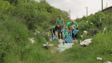 Gönüllü ekip plastik torbalar ve şişelerden kirli parkı temizliyor. Çöp selofan kirliliğini azaltır
