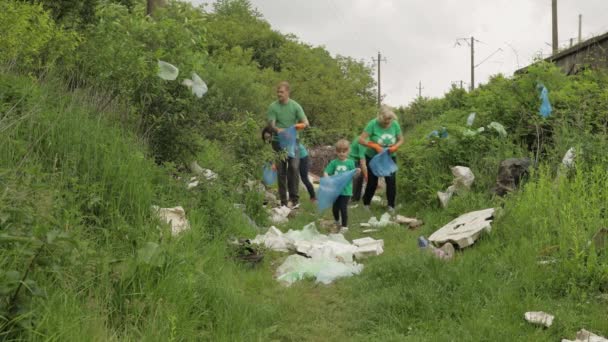 Zespół wolontariuszy sprząta brudny park z plastikowych toreb, butelek. Zmniejszenie zanieczyszczenia celofanem pochodzącym ze śmieci — Wideo stockowe