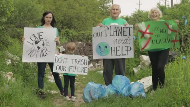 Önkéntes csapat bátorító plakátokkal. Szlogeneket kiabál. A szemetes celofán szennyezésének csökkentése — Stock videók