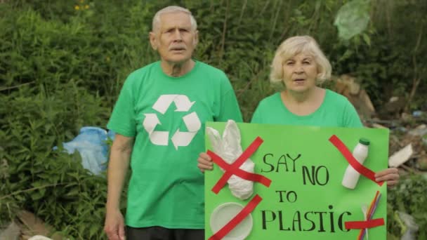 Voluntarios veteranos con afiche de protesta dicen no al plástico. Contaminación natural. Reciclar basura — Vídeos de Stock