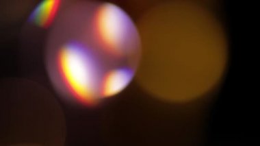 Işık sızıntısı 4K görüntüsü. Lens parlaklığı bokeh örtüleri, yanan alev arka planı. Flaş ışınları etkisi