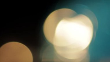 Çok renkli ışık siyah arkaplanda 4K görüntü sızdırıyor. Görüntüler, dönüşümler. Bokeh etkisi