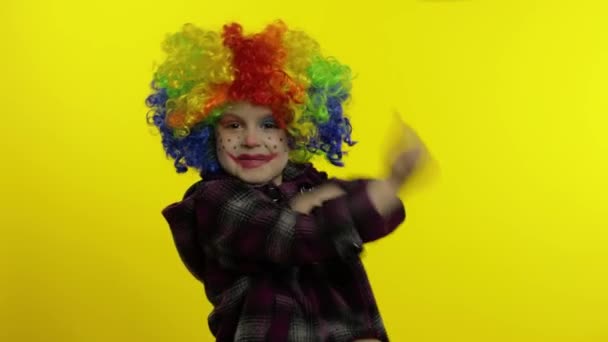 Menino palhaço menina em peruca colorida fazendo caras bobas, se divertindo, sorrindo, dançando. Halloween. — Vídeo de Stock