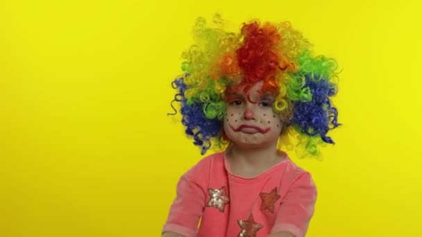 Menino palhaço menina em peruca colorida fazendo caras bobas, se divertindo, sorrindo, dançando. Halloween. — Vídeo de Stock