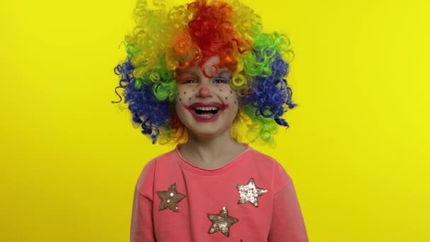 Little child girl clown in rainbow wig making silly faces. Having fun, smiling, laughing. Halloween — Stock Footage Little child girl clown in rainbow wig making silly faces. Having fun, smiling, laughing. Halloween Stock Video