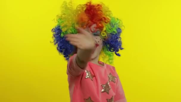 Pequeña niña payaso en colorido peluca agitando las manos, divertirse, sonreír. Halloween — Vídeo de stock