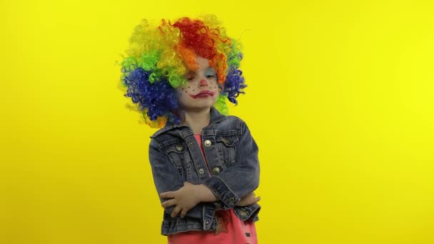 Petite fille clown en perruque colorée faisant des visages stupides. Fou, souriant, dansant. Halloween — Video