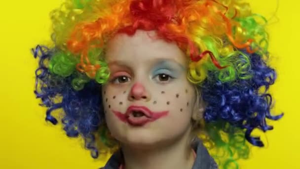 Petite fille clown en perruque colorée raconte quelque chose d'intéressant. Amusez-vous, souriant. Halloween — Video