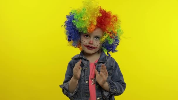 Child girl clown in wig making silly faces. Having fun, shows the movements of mime. Halloween — Stock Video