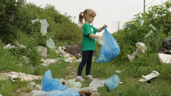 Plastik torbalar ve şişelerden kirli parkı temizleyen gönüllü kız. Çöp Doğa Kirliliğini Azalt