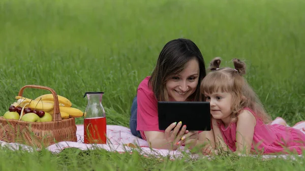 Családi hétvégi piknik. Lánya gyermek lány anya tanulási leckéket tabletta. Távolsági oktatás — Stock Fotó