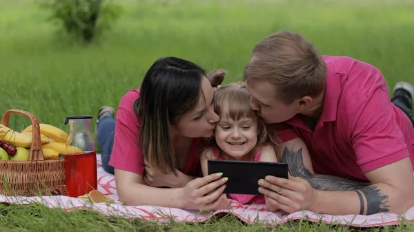 Családi hétvégi piknik. Lány gyermek lány anya és apa játék online játékok tabletta — Stock Fotó