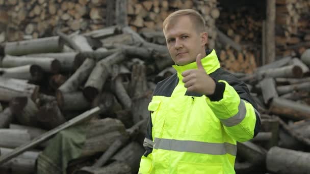 Ламберджек у відбиваючій куртці. Чоловік дроворуб з невеликою сокирою. Пиляні колоди, фон з дров — стокове відео