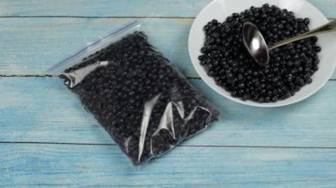 Buz tutmak için plastik poşetlerde yaban mersini paketleri. Donmuş ve korunmuş meyveler.