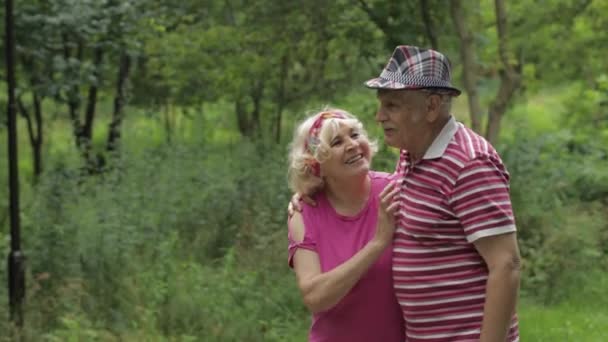 Couple caucasien sénior marchant dans le parc embrassant. Un homme âgé marche avec une femme. Mari, femme — Video