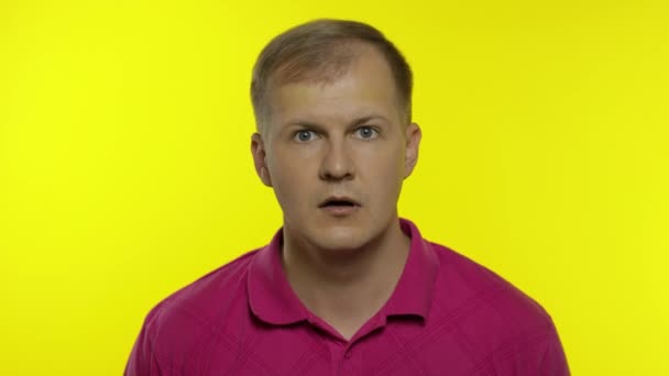 Portræt af ung kaukasisk mand, der poserer i lyserød t-shirt. Fantastisk flot fyr chokeret, overrasket – Stock-video