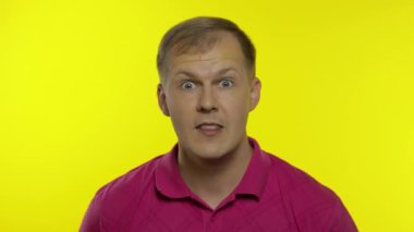 Pembe tişörtle poz veren beyaz adamın portresi. Şaşırmış yakışıklı adam şaşırdı, şaşırdı, 