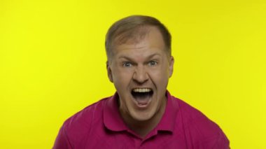 Pembe tişörtlü genç bir adamın portresi. Mutlu yakışıklı adam yüksek sesle gülüyor, kameraya bakıyor.