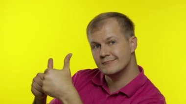 Tişörtle poz veren beyaz bir adamın portresi. Gülümseyen yakışıklı adam baş parmağını kaldırdı. İnsanların duyguları