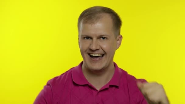 Retrato de un joven caucásico posando en camiseta rosa. Feliz chico guapo celebra y baila — Vídeos de Stock