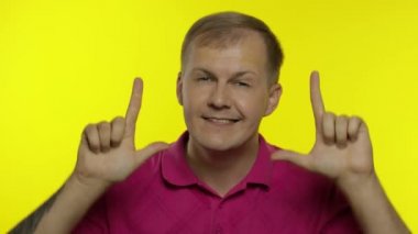 Pembe tişörtle poz veren beyaz bir gencin portresi. Mutlu yakışıklı adam kutlar ve dans eder.