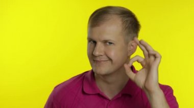 Tişörtle poz veren beyaz bir adamın portresi. Gülümseyen yakışıklı tamam işareti gösteriyor. İnsanların duyguları