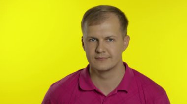 Tişörtle poz veren beyaz bir adamın portresi. Gülümseyen yakışıklı tamam işareti gösteriyor. İnsanların duyguları