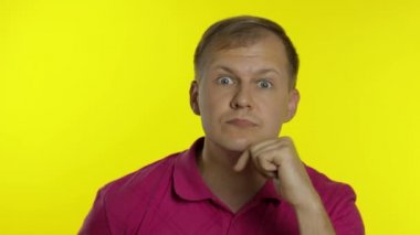 Pembe tişörtlü bir adamın portresi. Çılgın yakışıklı adam komik suratlar yapıyor, dudaklarıyla oynuyor.