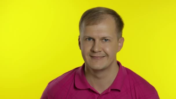 Retrato de homem caucasiano posando em t-shirt. Um tipo bonito e sorridente mostra o polegar. Pessoas emoções — Vídeo de Stock