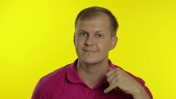 Portret mężczyzny pozującego w różowej koszulce. Szczęśliwy facet prosi o telefon, pokazuje telefon z ręką. — Wideo stockowe